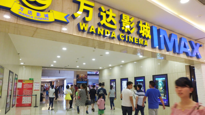 Shenzhen bourse queries Wanda Cinema's planned purchase of movie affiliate --FILE--Chinese filmgoers visit a Wanda Cinema featuring IMAX in Yichang city, central China's Hubei province, 6 May 2016.
China's Wanda Cinema Line Corp said it has been asked by the Shenzhen stock exchange to provide more information about its proposed $6 billion acquisition of a sister company that owns U.S. film studio Legendary Entertainment. Chinese tycoon Wang Jianlin's Wanda Group bought the Hollywood Studio for $3.5 billion in 2016 via its Wanda Media movie-making unit. Wanda Cinema proposed a cash and share acquisition of unlisted Wanda Media this month. "The company is actively coordinating and preparing a reply and will provide supplementary information to perfect the proposal," Wanda Cinema said in an announcement. The proposed acquisition is pending approval from shareholders and regulators, it added. It gave no further details. Wanda Cinema has also said it plans to raise 8 billion yuan ($1.2 billion) in a share sale to fund the building of theatres and replenish working capital.